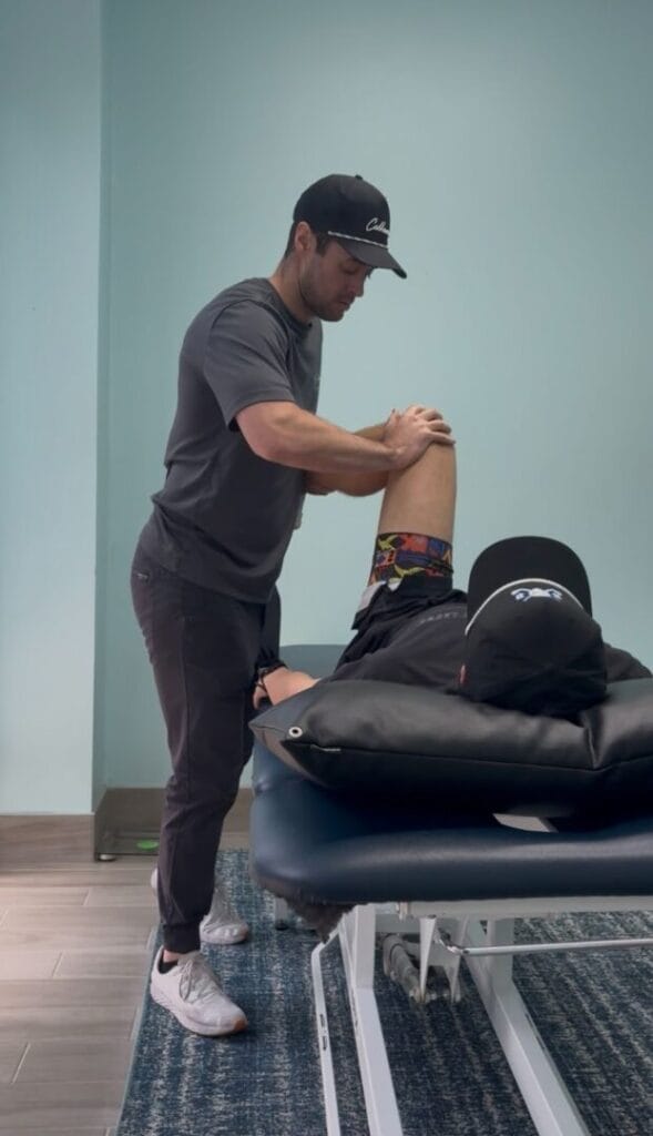 Cody working with a golfer on stretches for his hips.